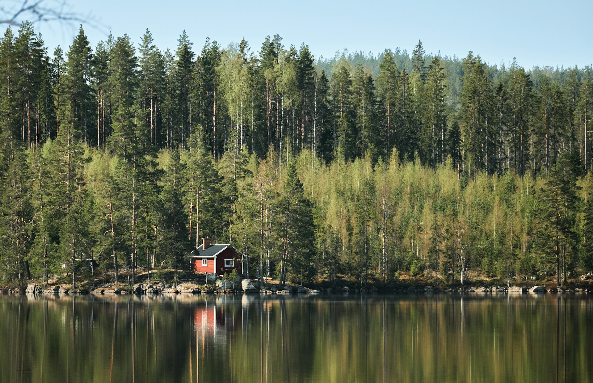 Rotes Holzhaus am See in Dalarna, typisch für ein Ferienhaus in Schweden zum Mieten