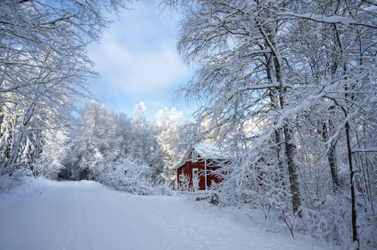 Rotes Holzhaus im verschneiten Wald bei Kopparberg in Schweden