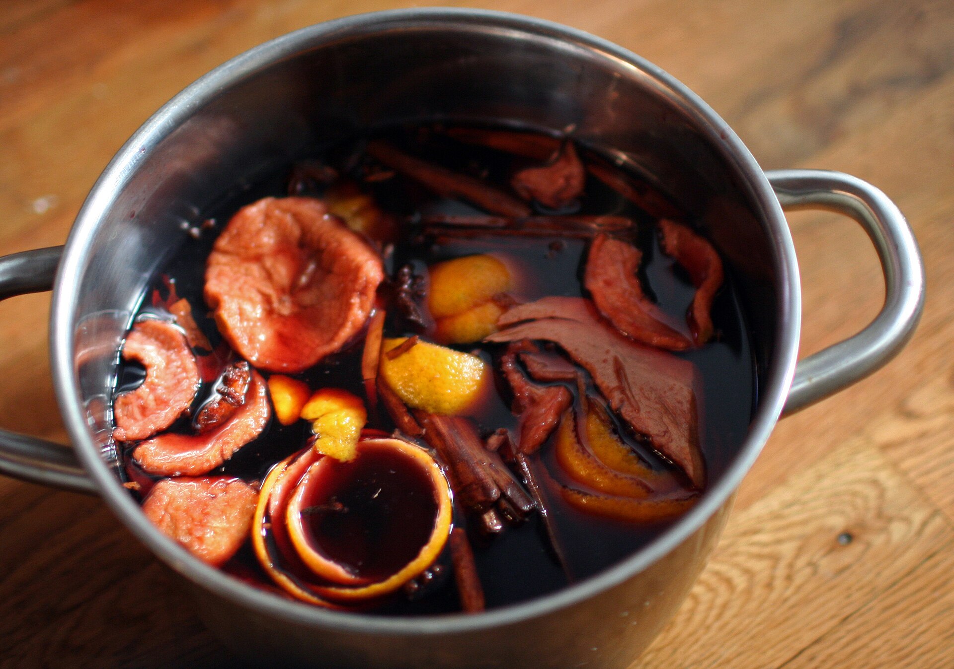 Glögg Rezept: selbst gemachter schwedischer Glögg mit Zimtstangen und Orangenschalen zieht im Topf