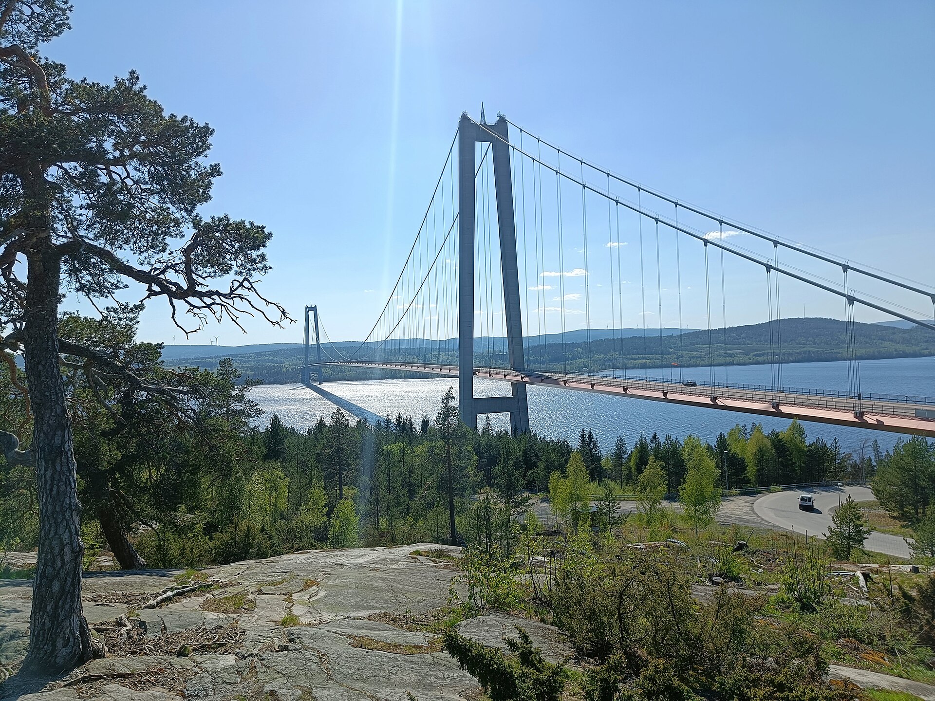 Höga Kusten: Hängebrücke Högakustenbron über den Ångermanälven, im Vordergrund Kiefern und glatter Granitfels