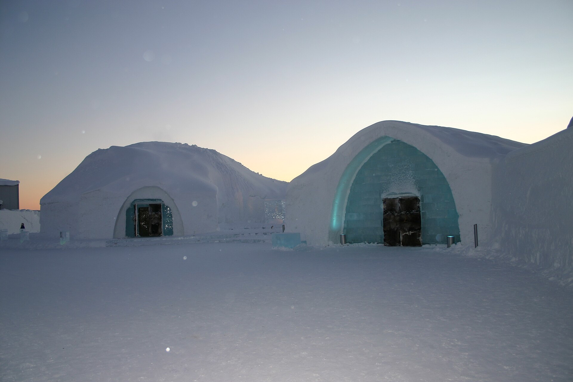 Icehotel in Jukkasjärvi: zwei Hallen aus Schnee mit Eingängen aus Eisblöcken in der Abenddämmerung