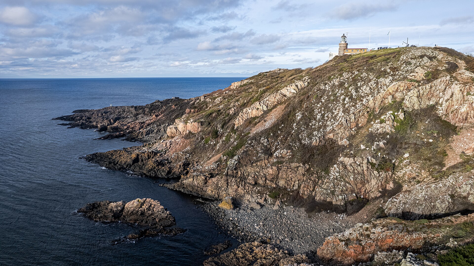 Kullaberg in Skåne: Luftaufnahme der Klippen an der Spitze der Halbinsel mit dem Leuchtturm Kullens fyr und einer Bucht aus runden Steinen