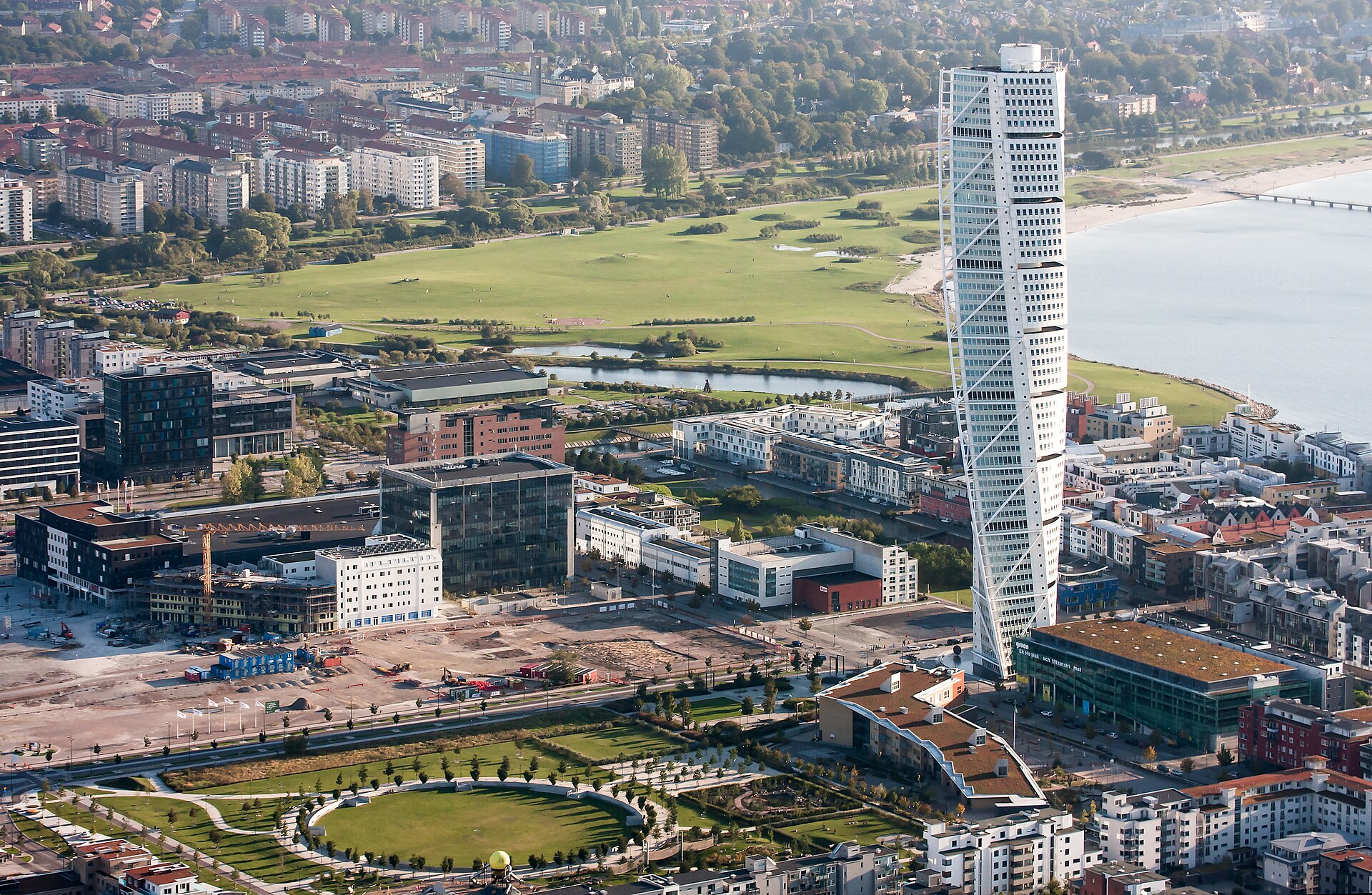 Malmö Sehenswürdigkeiten: Turning Torso in Västra Hamnen aus der Luft, im Hintergrund die Küste am Öresund
