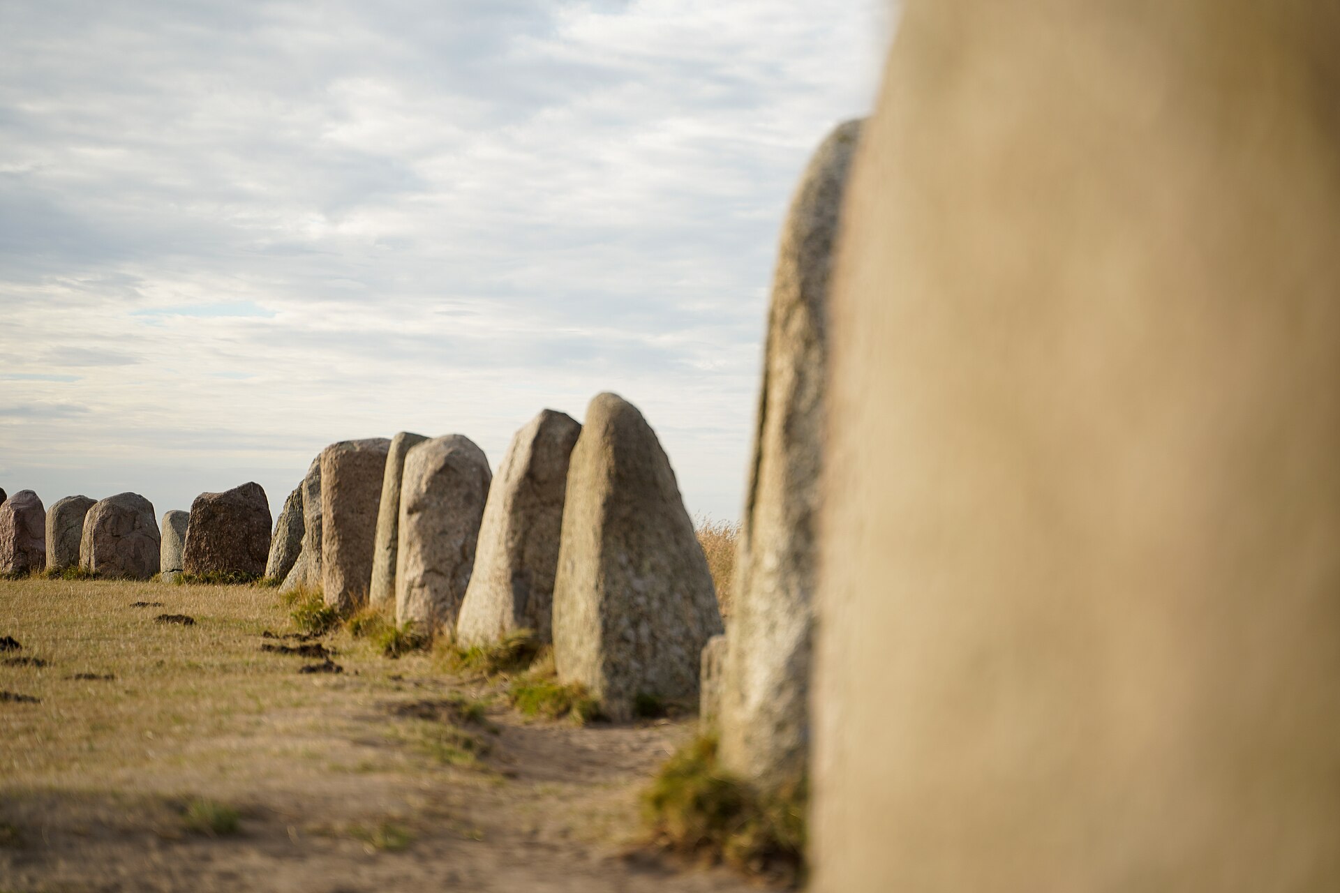 Schweden Sehenswürdigkeiten: Ales stenar, die Schiffssetzung aus großen Steinen bei Kåseberga in Skåne, unter bewölktem Abendhimmel