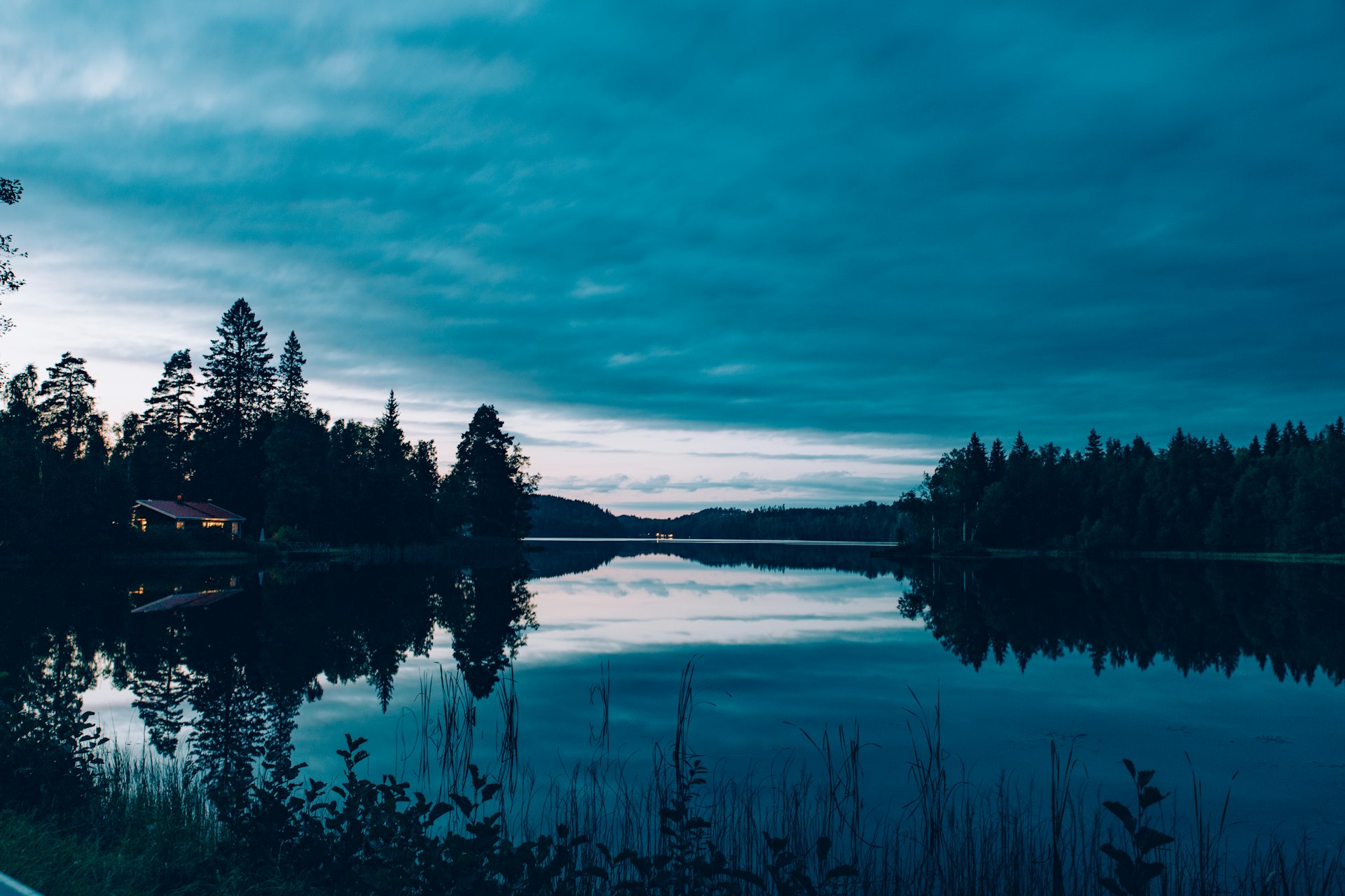 Urlaub in Småland: stiller Waldsee am Abend mit Holzhaus am Ufer bei Nässjö