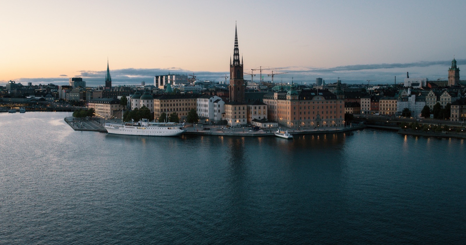 Städte in Schweden: Stockholms Altstadt mit Riddarholmskyrkan am Wasser in der Dämmerung