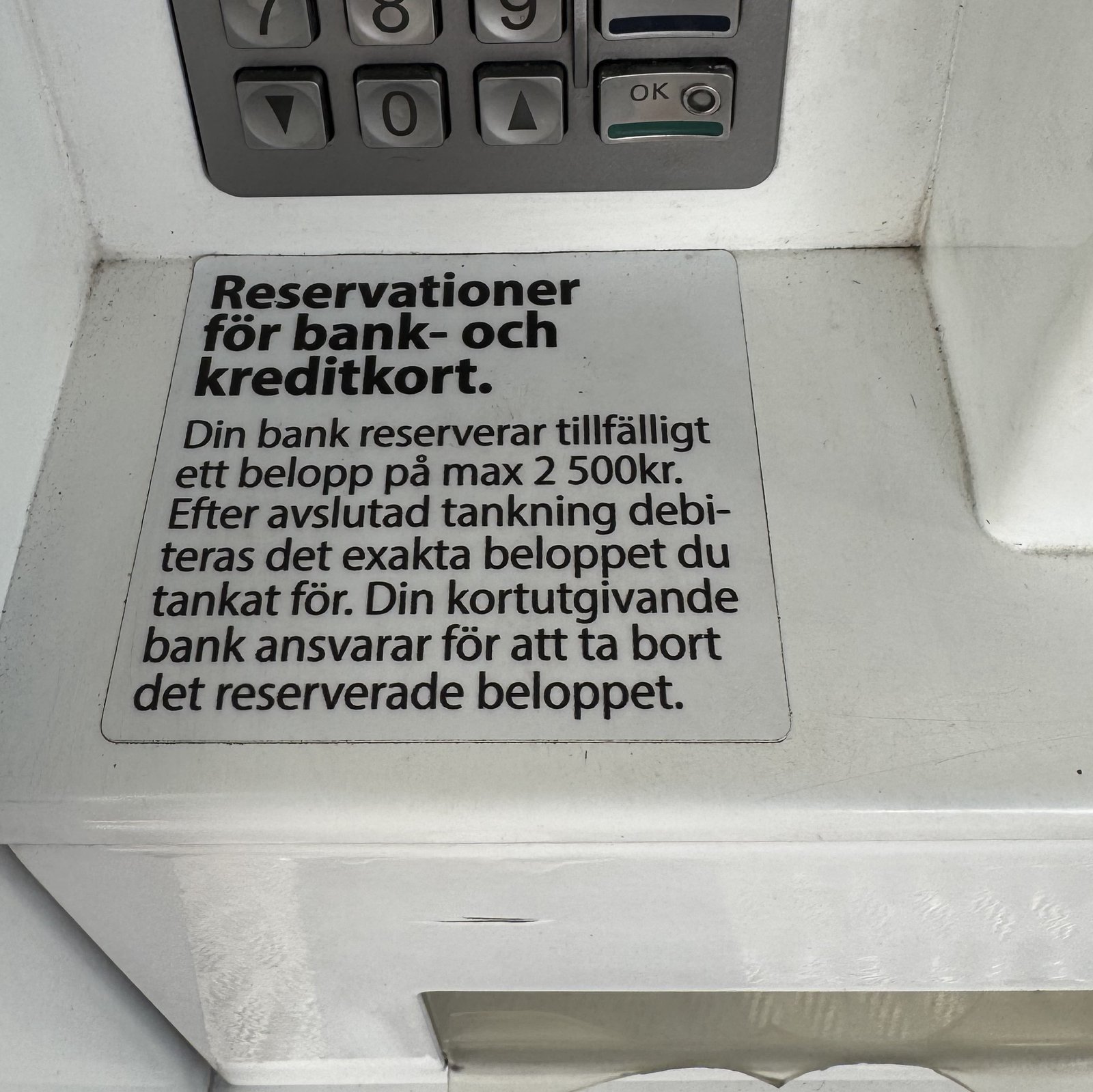 Aufkleber am Tankautomaten einer dinX-Station in Svedala: Reservationer för bank- och kreditkort, die Bank reserviert vorübergehend höchstens 2.500 Kronen