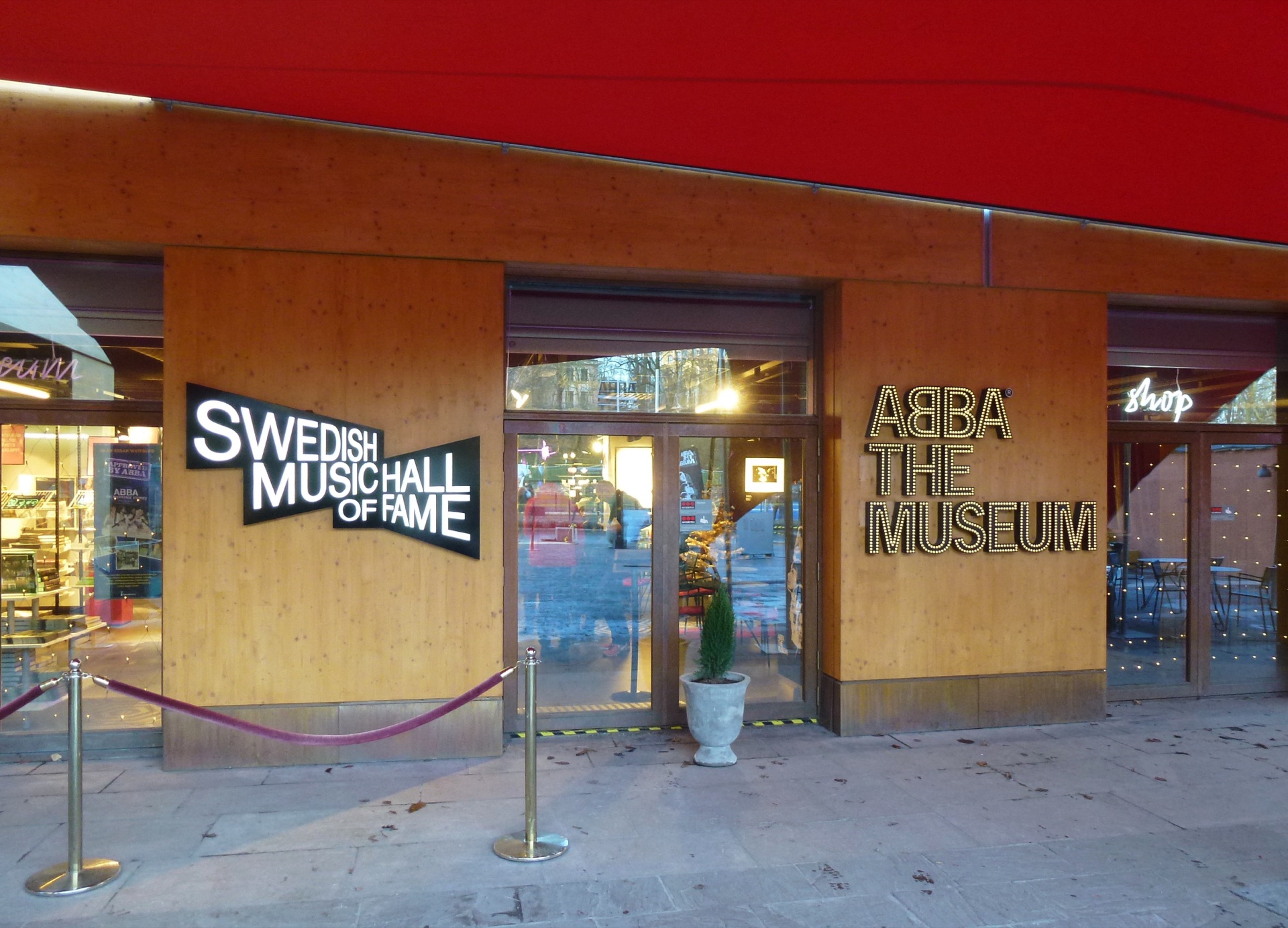 Eingang von ABBA The Museum auf Djurgården in Stockholm mit Leuchtschrift an der Holzfassade