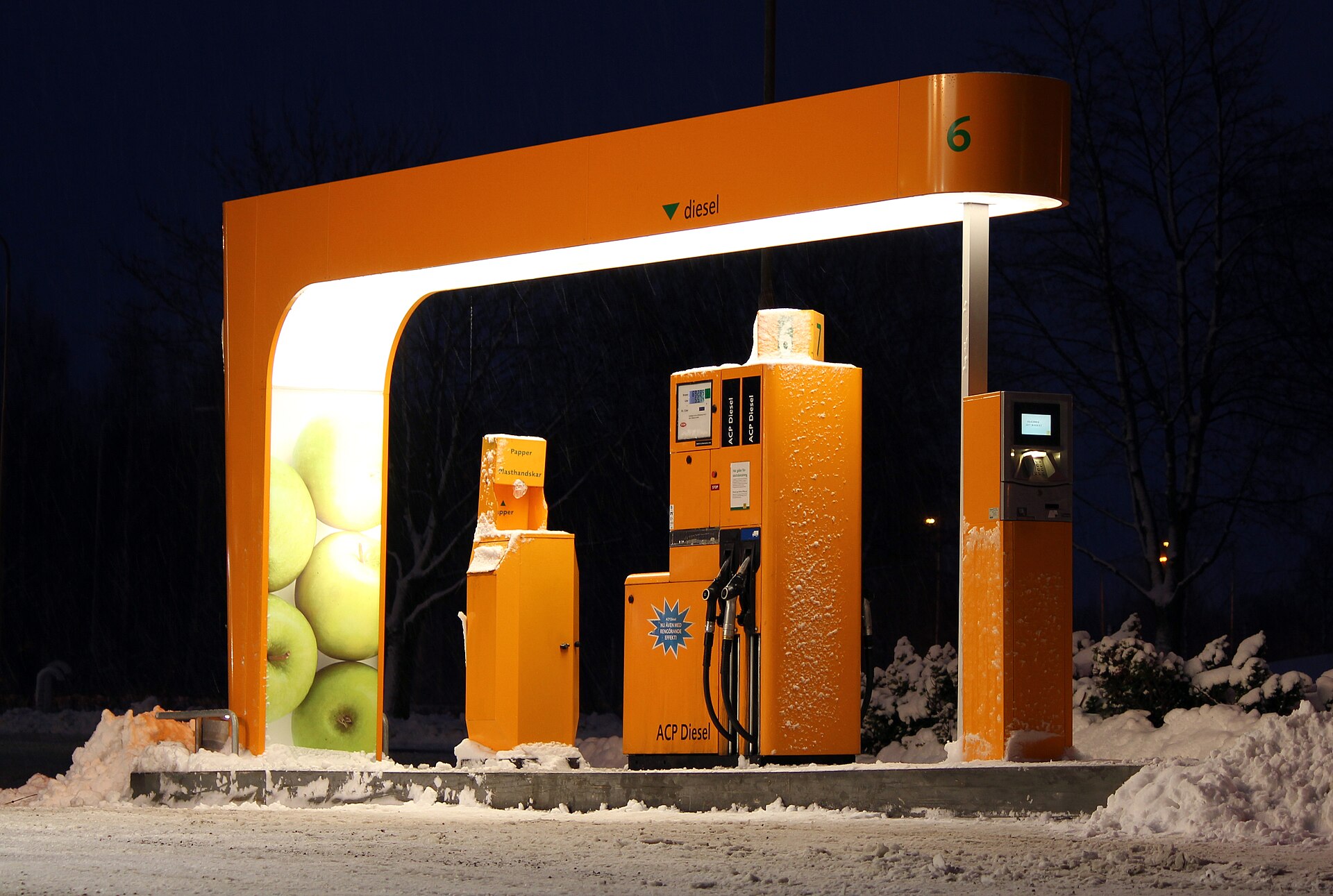 Dieselzapfsäule unter leuchtendem Dach bei Nacht im Schnee an einer schwedischen Tankstelle