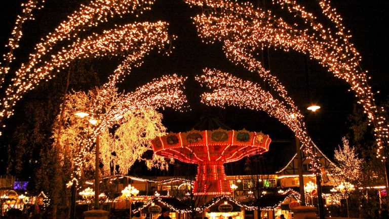 Weihnachtsbeleuchtung im Freizeitpark Liseberg in Göteborg mit Lichterbögen über dem Kettenkarussell