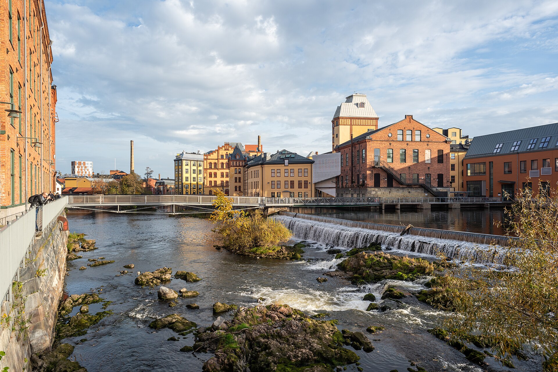 Der Fluss Motala ström mit Wehr und historischen Fabrikgebäuden aus Backstein in Norrköping