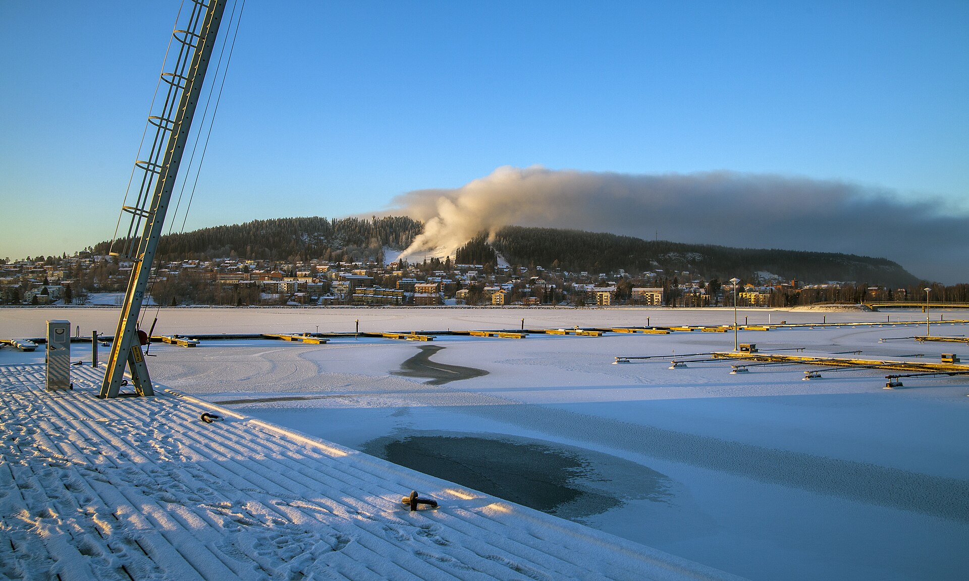Winterblick über den zugefrorenen Storsjön auf Frösön bei Östersund unter blauem Himmel