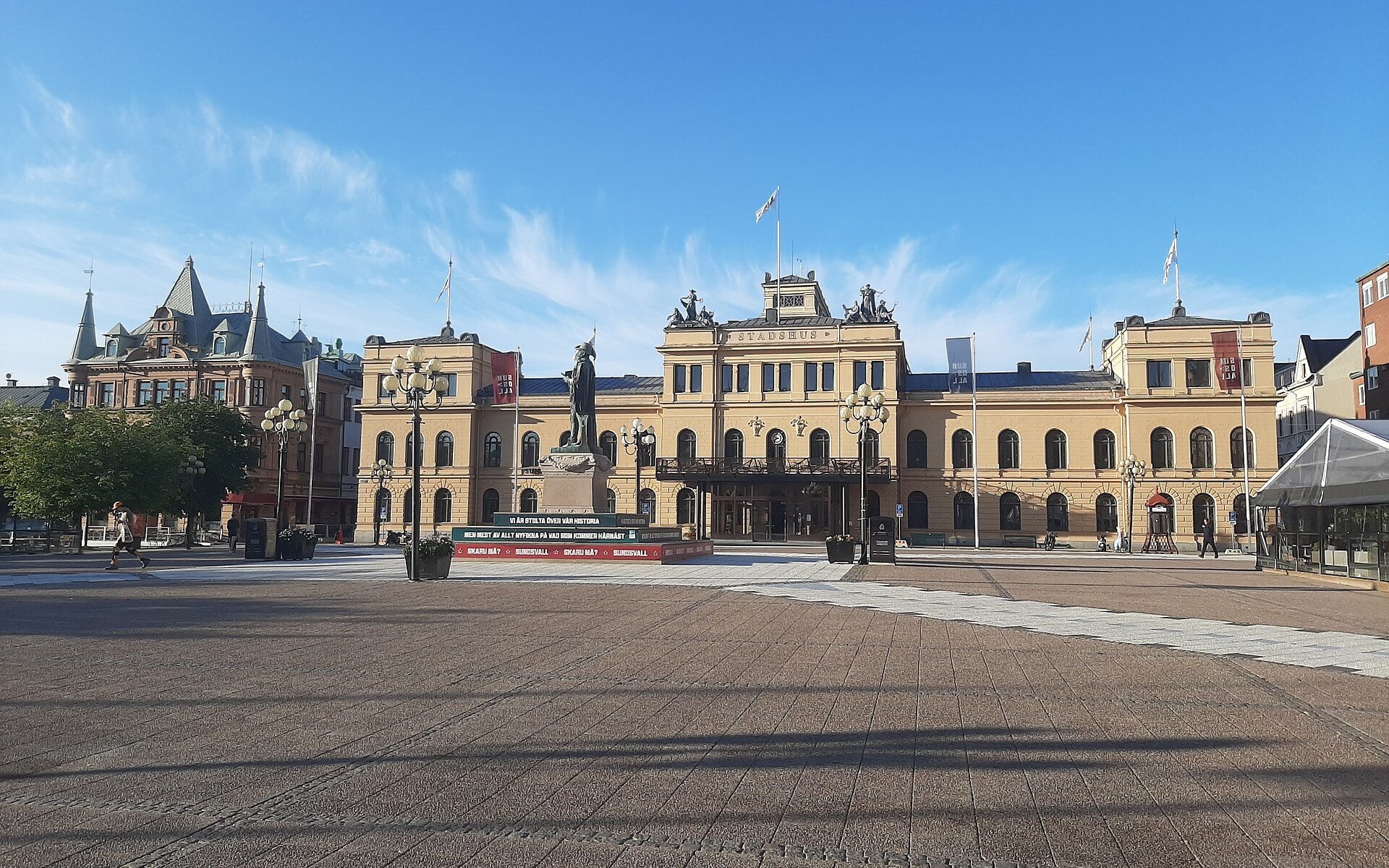 Stora torget in der Steinstadt von Sundsvall mit dem gelben Stadshuset unter blauem Himmel