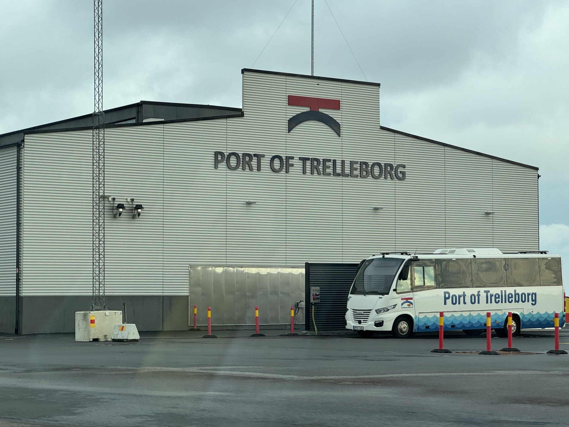 Halle mit der Aufschrift Port of Trelleborg, davor ein weißer Kleinbus mit dem Hafenlogo