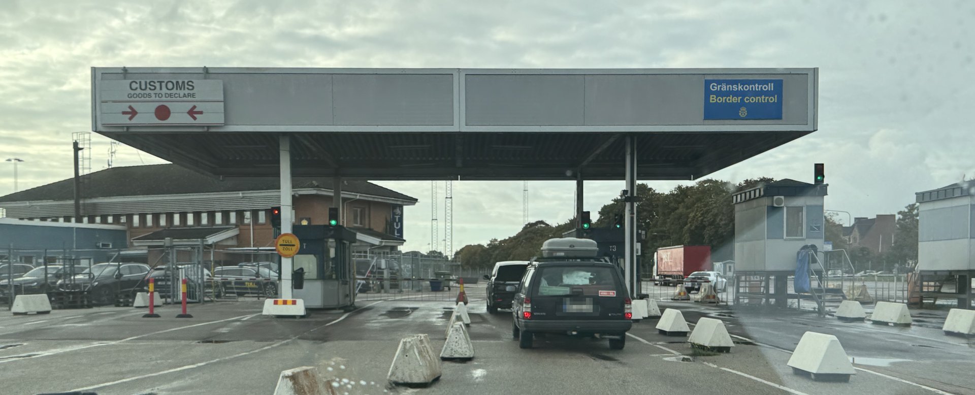 Zollkontrolle im Hafen Trelleborg: links das Schild Customs, goods to declare mit roten Pfeilen, rechts der Hinweis Gränskontroll, Border control, Autos in der Spur