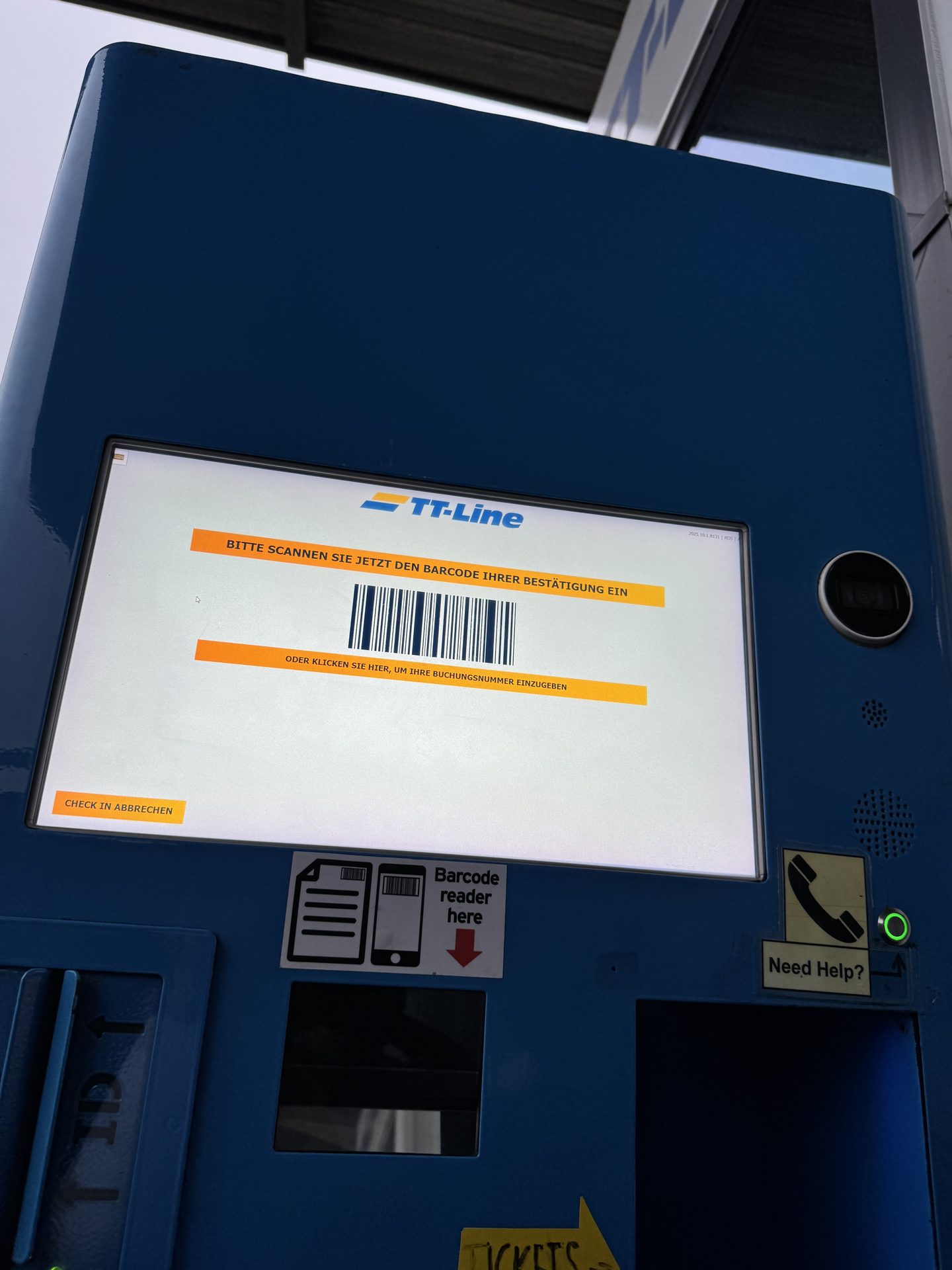 Self-Check-in-Automat von TT Line im Hafen Rostock, auf dem Bildschirm die Aufforderung, den Barcode der Buchungsbestätigung zu scannen